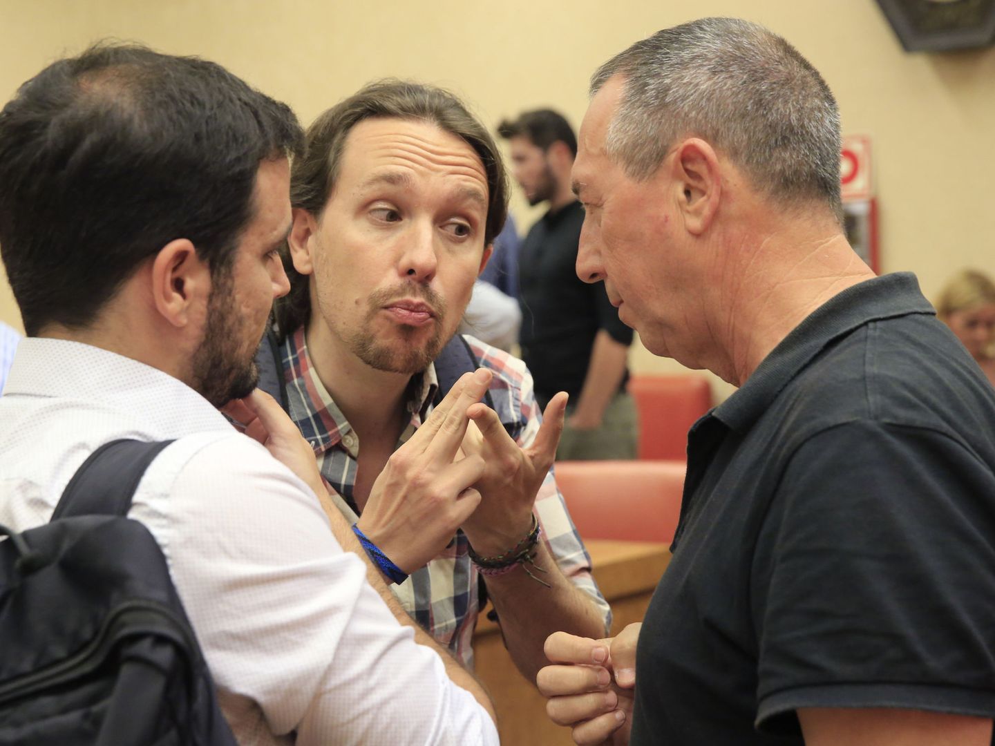 El secretario general de Podemos, Pablo Iglesias (c), conversa con el líder de IU, Alberto Garzón (i) y con el portavoz de Compromís en el Congreso, Joan Baldoví. (EFE)