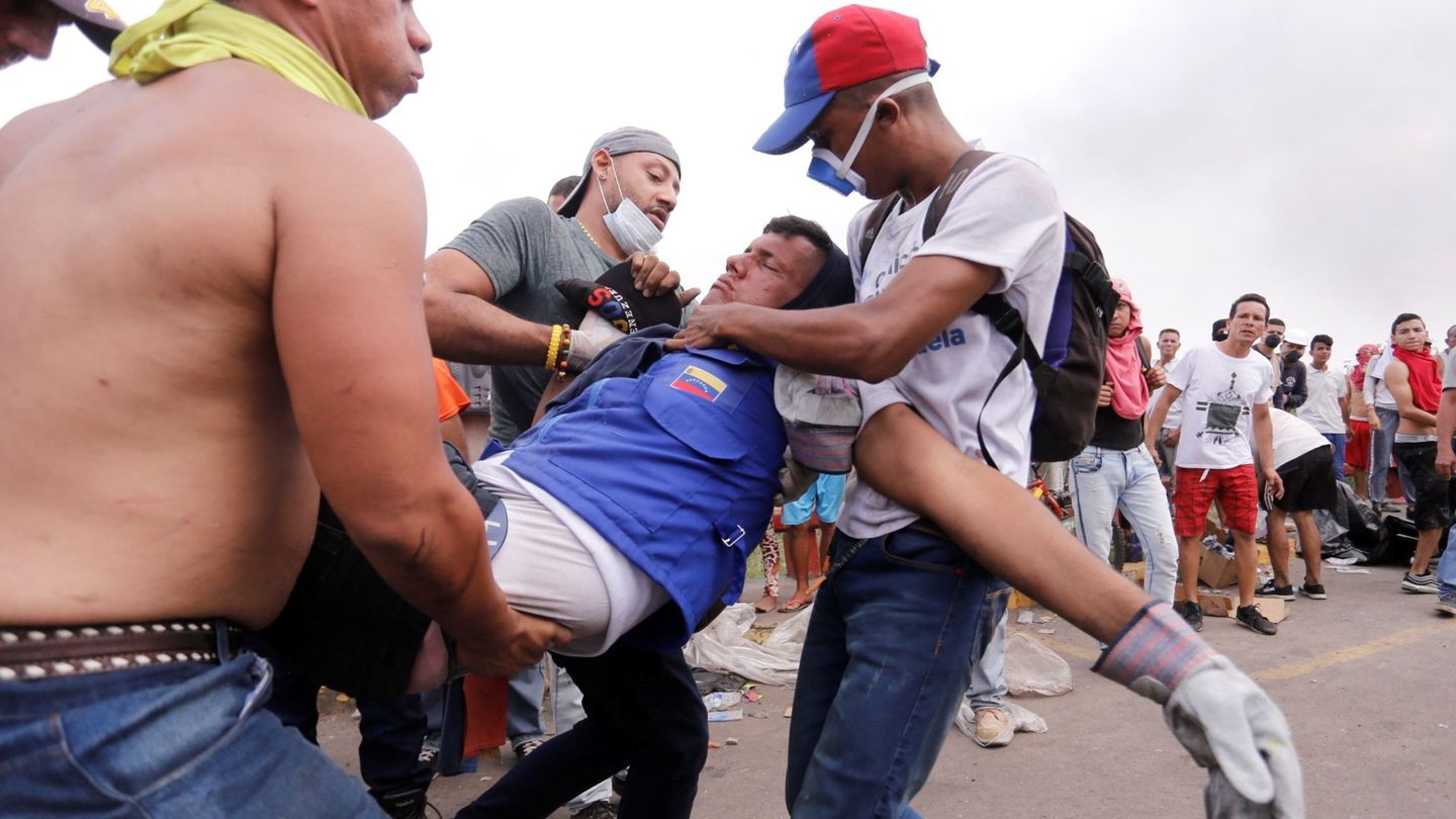 Un hombre herido durante los enfrentamientos es ayudado en Ureña, Venezuela. (EFE)