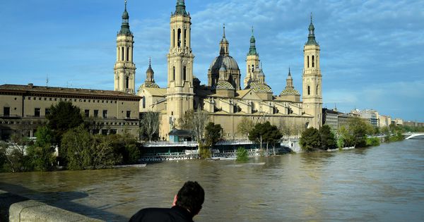 Foto: Un hombre observa la crecida del Ebro a su paso por Zaragoza. (Reuters)