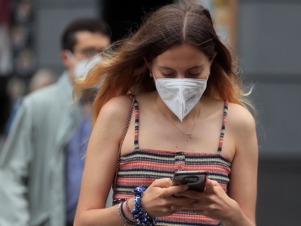 Foto: Una chica pasea con mascarilla durante la pandemia del covid. (EFE) 