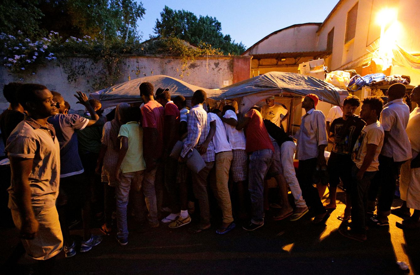 Inmigrantes hacen cola para recibir alimentos en un campamento improvisado en Via Cupa, Roma, en agosto de 2016. (Reuters)