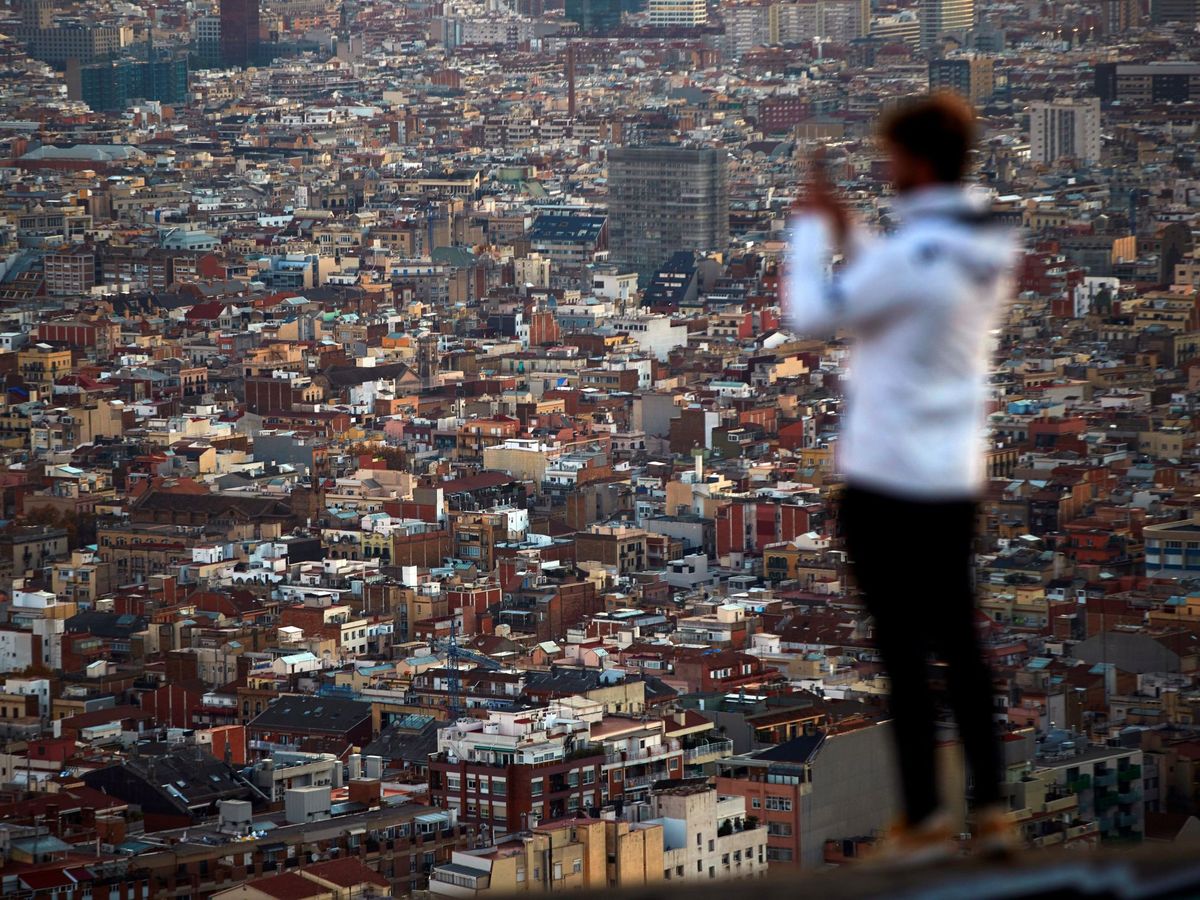 Foto: Una persona fotografía Barcelona desde los miradores de El Carmel. (EFE)