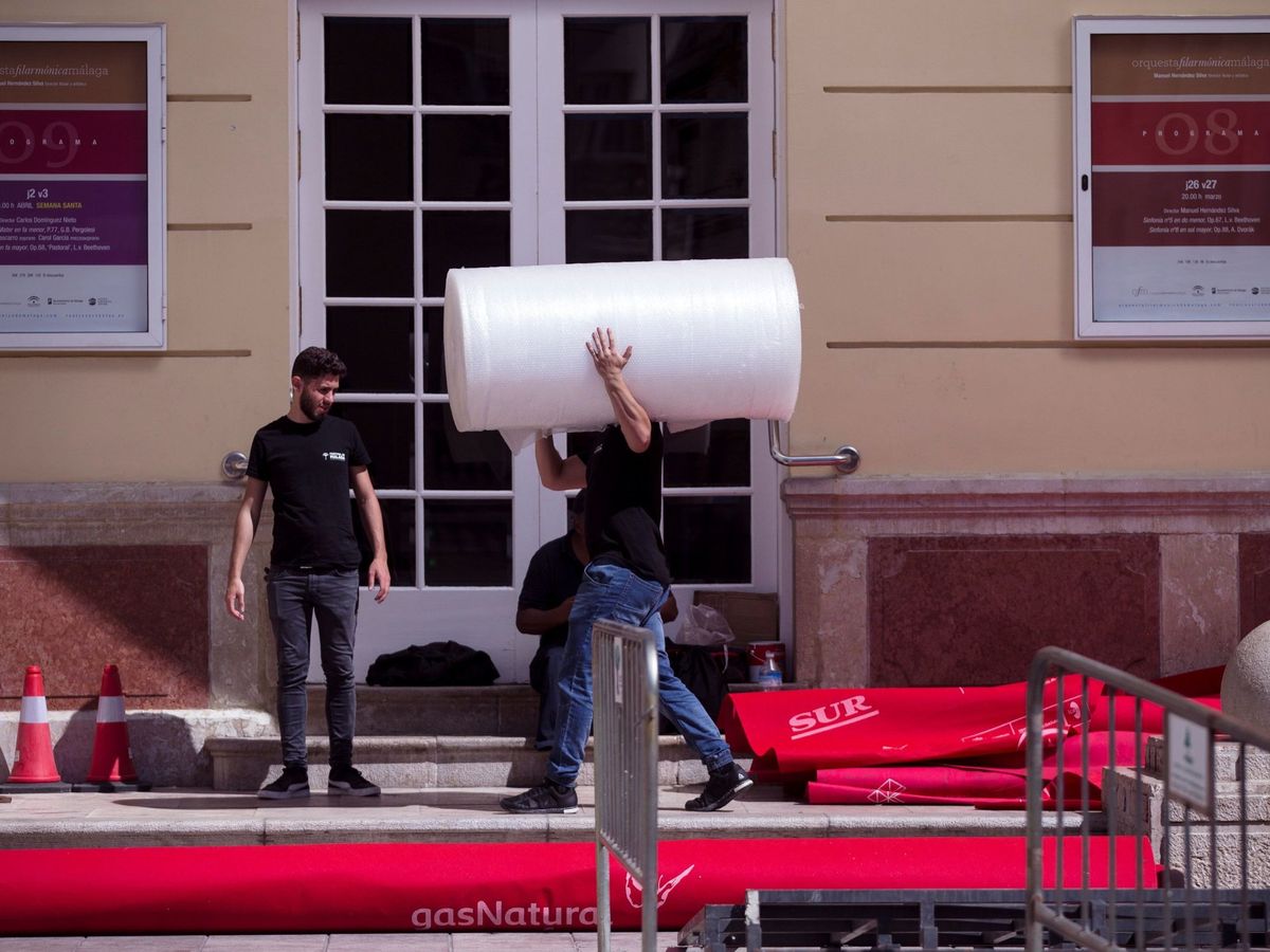 Foto: Técnicos recogen la alfombra roja del Festival de Málaga, aplazado la semana pasada por el coronavirus. (Efe)