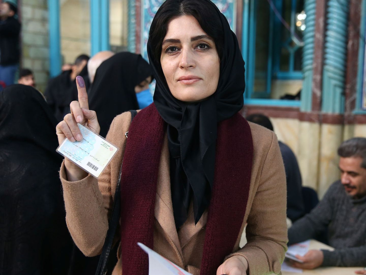 Una mujer muestra su dedo manchado de tinta, que demuestra que ha votado, en Irán. (Reuters)