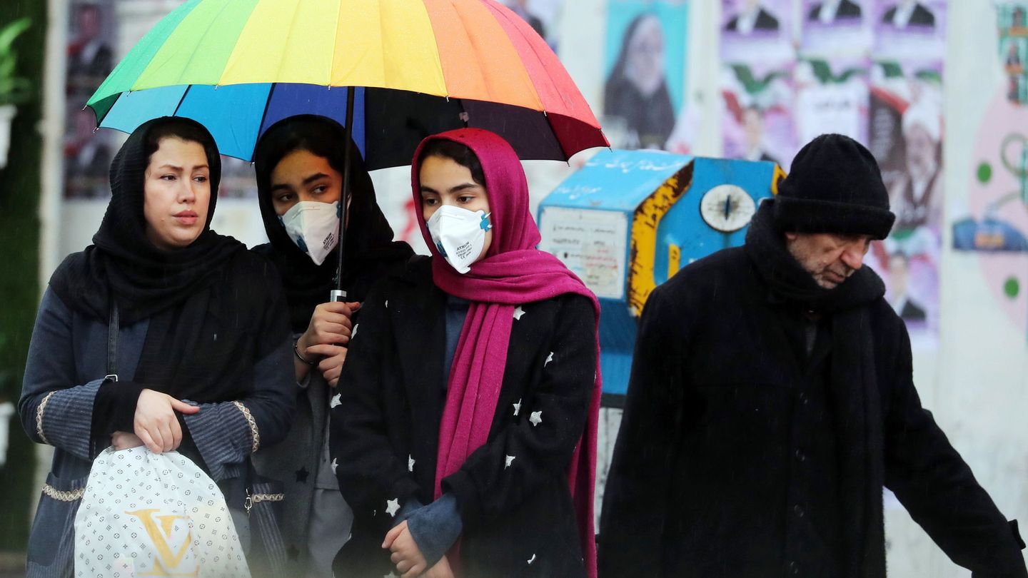 Mujeres iraníes con mascarilla esperan un taxi en Teherán. (EFE / EPA)
