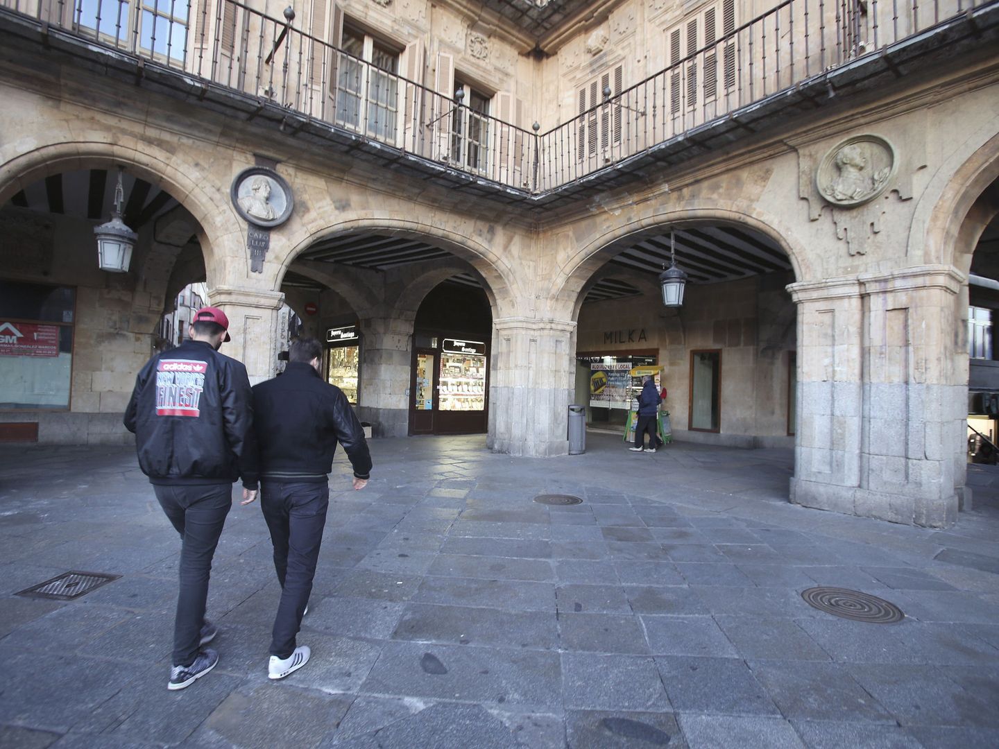 Dos personas pasan ante el medallón de Franco (d) en la Plaza Mayor de Salamanca. (EFE)