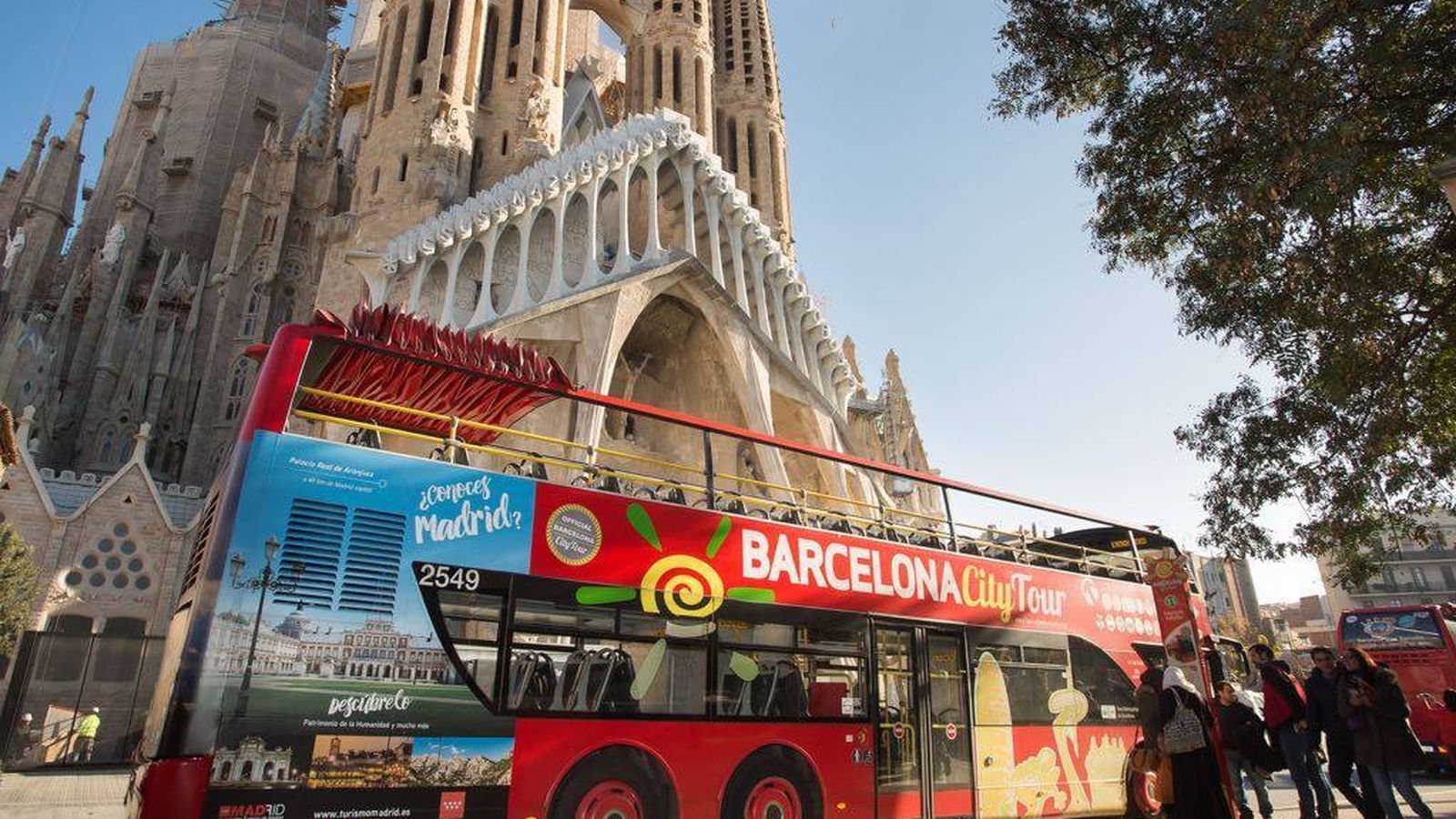 Foto: Uno de los autobuses turísticos con publicidad de la Comunidad de Madrid pasa por delante de la Sagrada Familia.