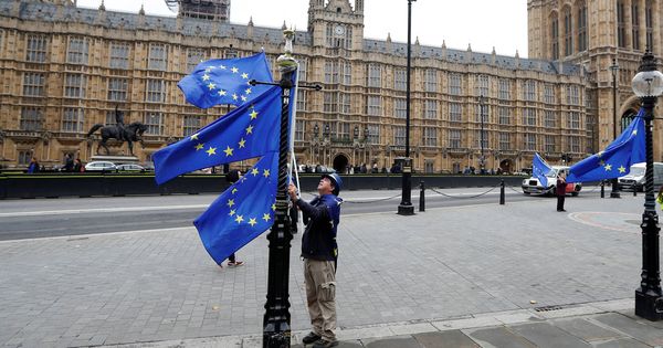 Foto: Un manifestante contrario al Brexit coloca banderas de la UE ante el Parlamento británico, en Londres. (Reuters)
