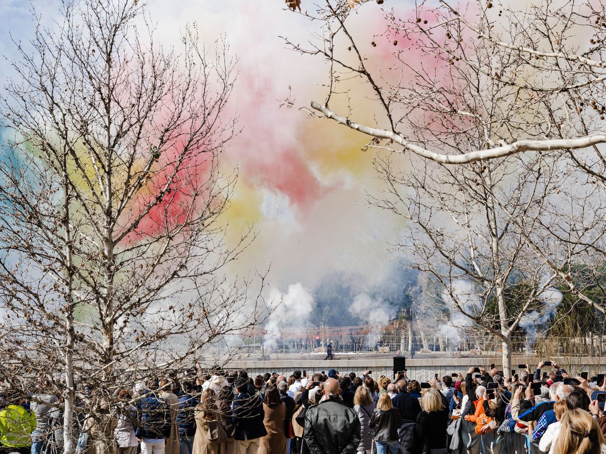 Foto: Decenas de personas observan el humo de colores durante la primera mascletà madrileña, en el Puente del Rey de Madrid Río. (Europa Press/Europa Press)
