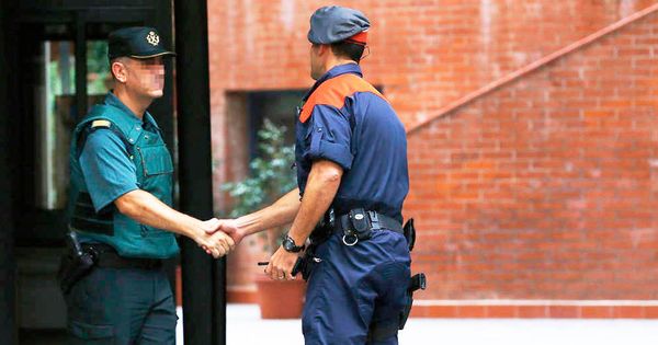 Foto: Un guardia civil y un mosso se saludan en la entrada de un cuartel. (EFE)