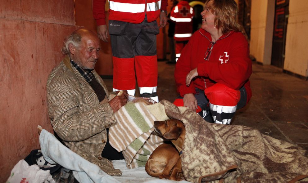Un indigente recibe comida del personal de Cruz Roja. (Foto: Cruz Roja)