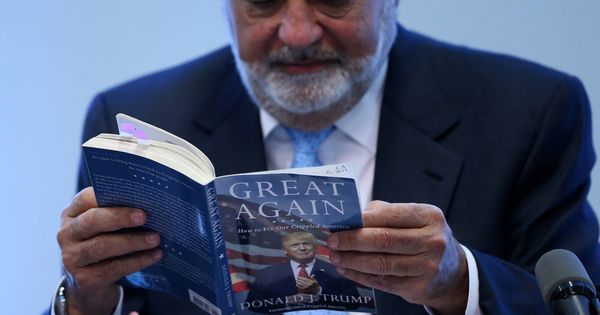 Foto: Carlos Slim lee el libro "How to make America great again" de Donald Trump durante una rueda de prensa en Ciudad de México, el 27 de enero de 2017. (Reuters)