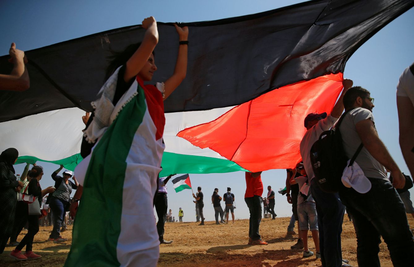 Árabes israelíes enarbolan una bandera palestina durante una manifestación a favor del derecho de retorno de los refugiados en Rahat, sur de Israel, en mayo de 2016 (Reuters)