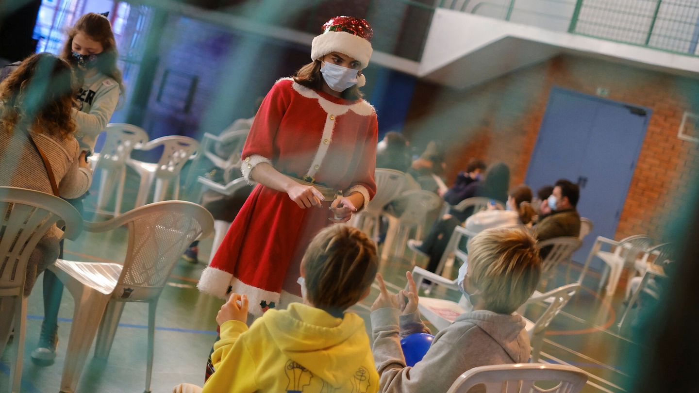 Una trabajadora vestida de Santa Calus entretiene a niños que van a ser vacunados en Lisboa. (Reuters/Pedro Nunes)