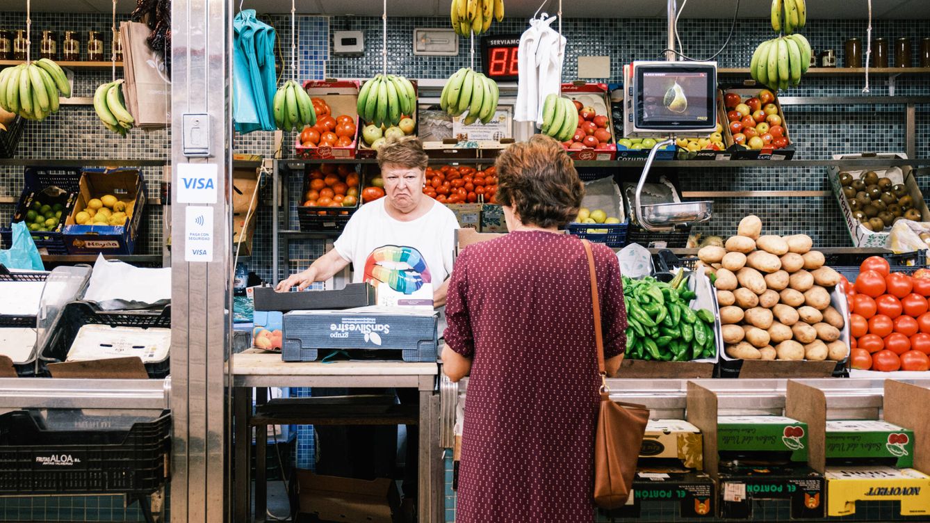 Foto: Una mujer comprando en una frutería del mercado de abastos de Dos Hermanas este lunes. (J. Z.)