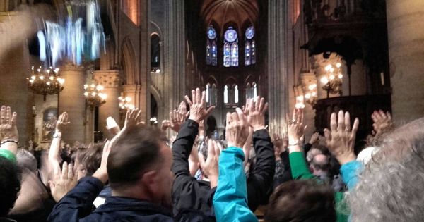 Foto: Imagen del interior de Notre Dame con todos los turistas con las manos en alto. (El Confidencial)