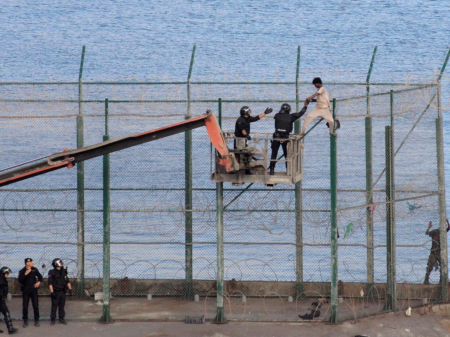  Un inmigrante subsahariano es detenido este viernes por la Policía española en la valla fronteriza de Ceuta con Marruecos. (EFE)