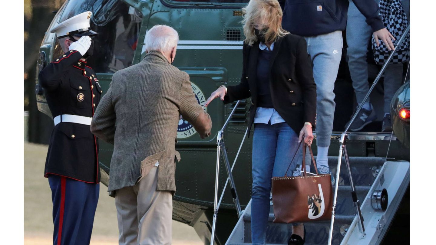 Joe Biden ayuda a Jill Biden (que lleva un bolso de Valentino) a bajar del avión. (Reuters)