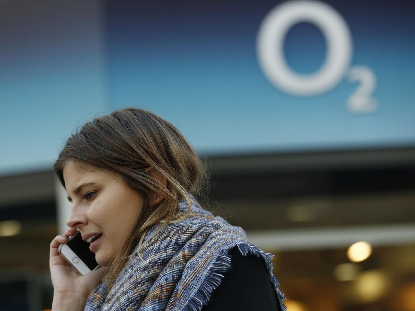 A woman speaks on a mobile telephone outside an O2 store in central London in this November 24, 2014 file photo. Li Ka-shing's Hutchison Whampoa Ltd has agreed to buy Telefonica's British mobile unit O2 for up to 10.25 billion pounds (.4 billion), as Asia's richest man makes his boldest bet yet to revamp his European telecoms business.  REUTERS/Luke MacGregor/Files  (BRITAIN - Tags: BUSINESS TELECOMS)