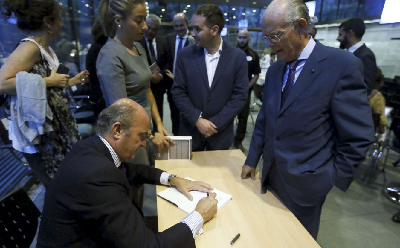 El ministro de Economía en funciones, Luis de Guindos, firma ejemplares de su libro 'España amenazada'. (EFE)