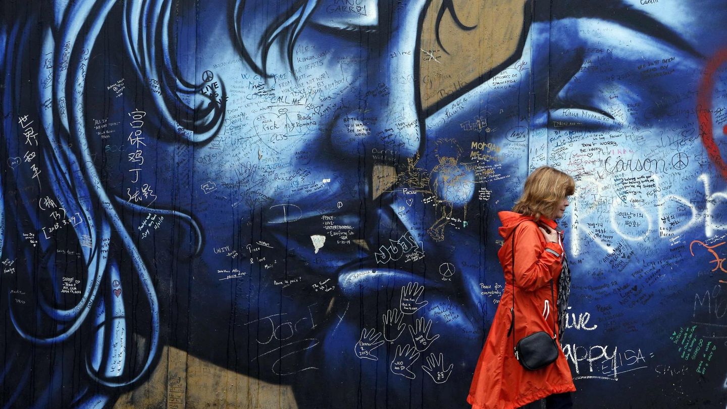 Una turista camina frente a un 'muro de la paz' en Irlanda del Norte. (Reuters)