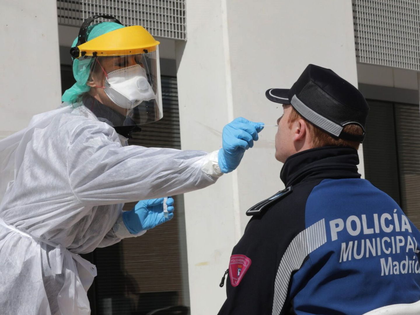 Una sanitaria realiza un test contra el coronavirus a un policía en Madrid. (EFE)