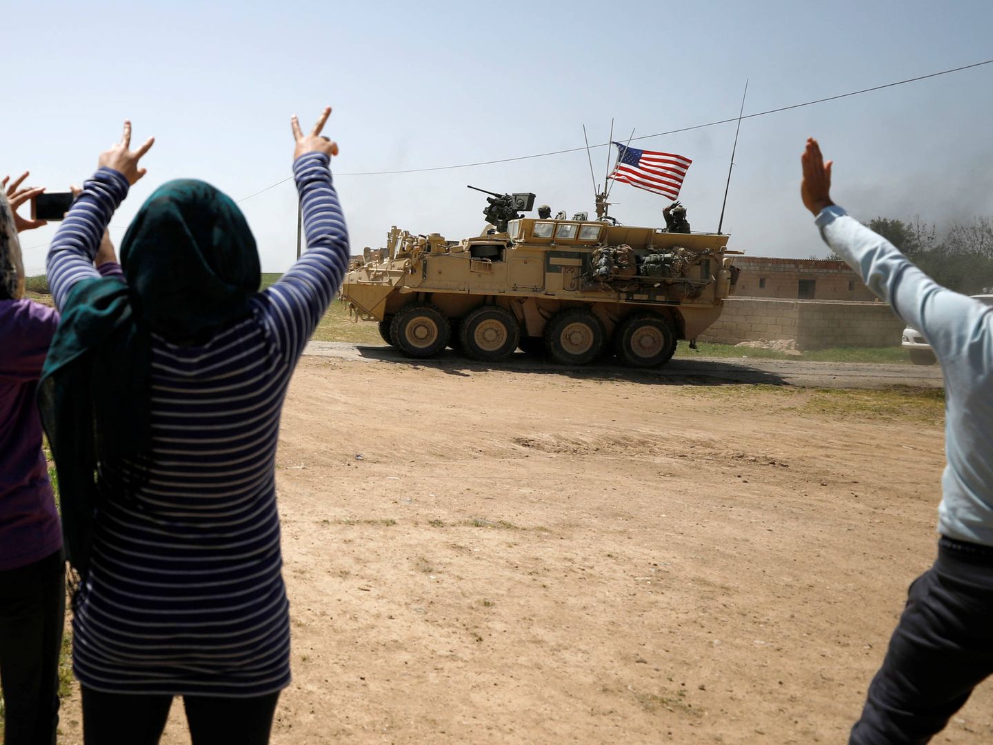 Sirios observan el paso de blindados estadounidenses en la provincia de Amuda, norte de Siria. (Reuters) 