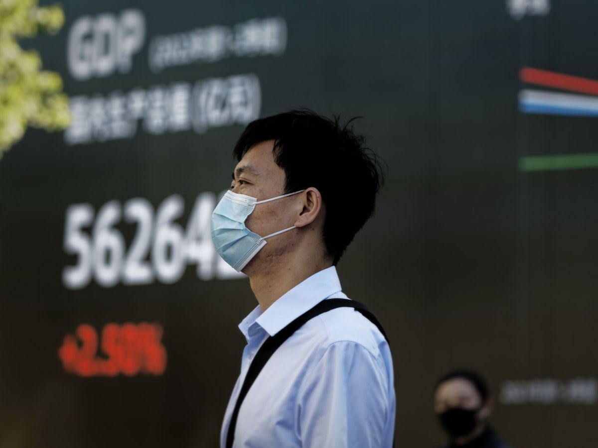 Foto: Un hombre frente a una pantalla que muestra las cifras de PIB en Shanghái, China. (EFE/Alex Plavevski)