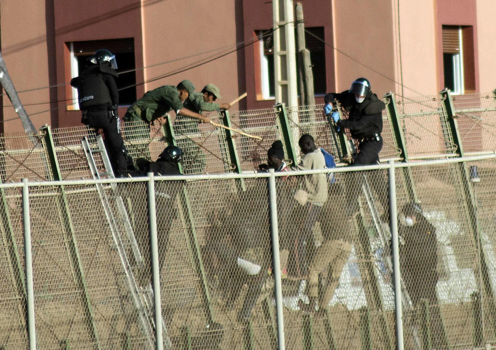 Foto: Inmigrantes y fuerzas de seguridad marroquíes en la valla de Melilla. (Reuters)