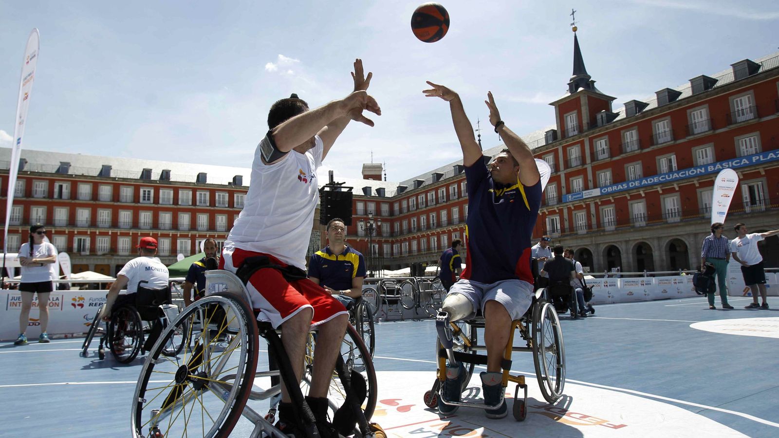 Foto: Dos jugadores del equipo paralímpico español en la Plaza Mayor de Madrid. (Paolo Aguilar/EFE)