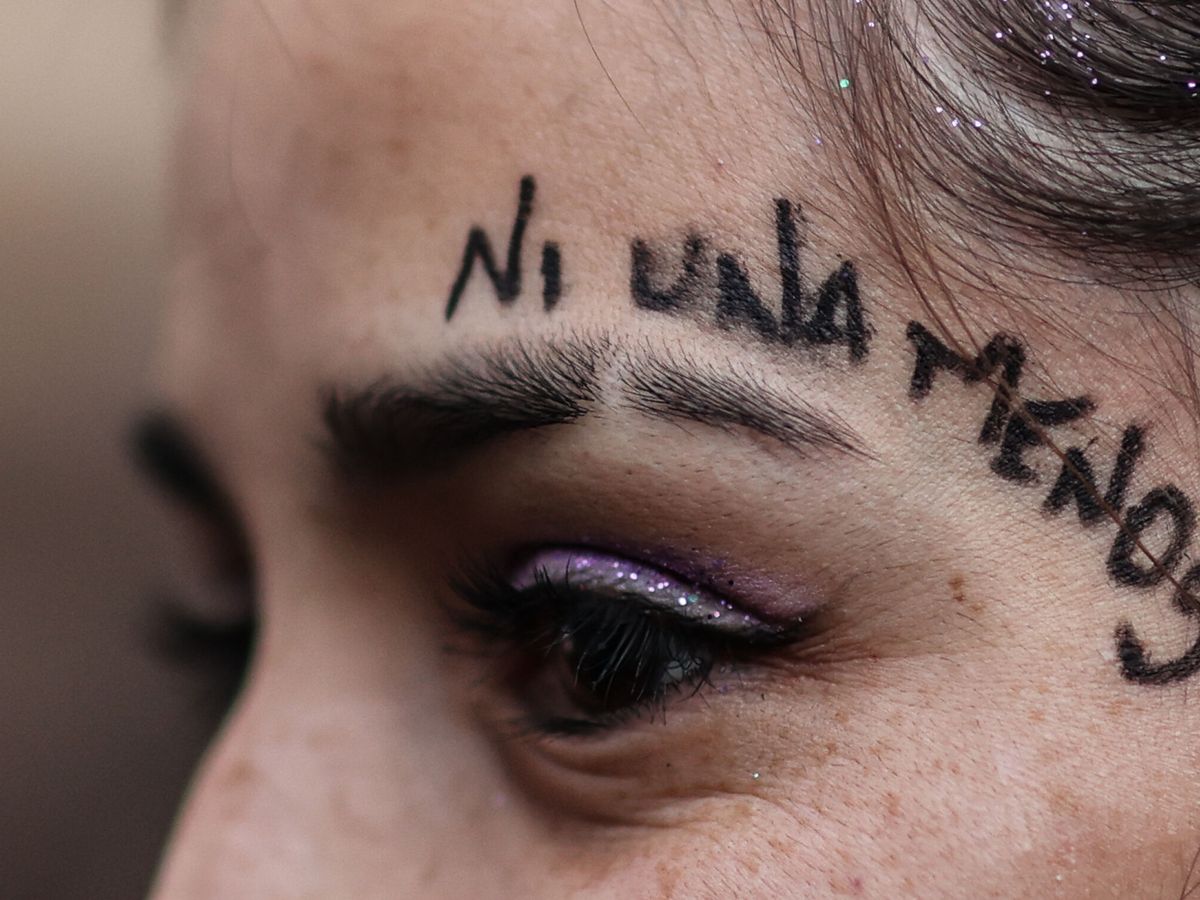 Foto:  Una mujer participa con miles de mujeres en una marcha contra la violencia de género. (EFE/Juan Ignacio Roncoroni)
