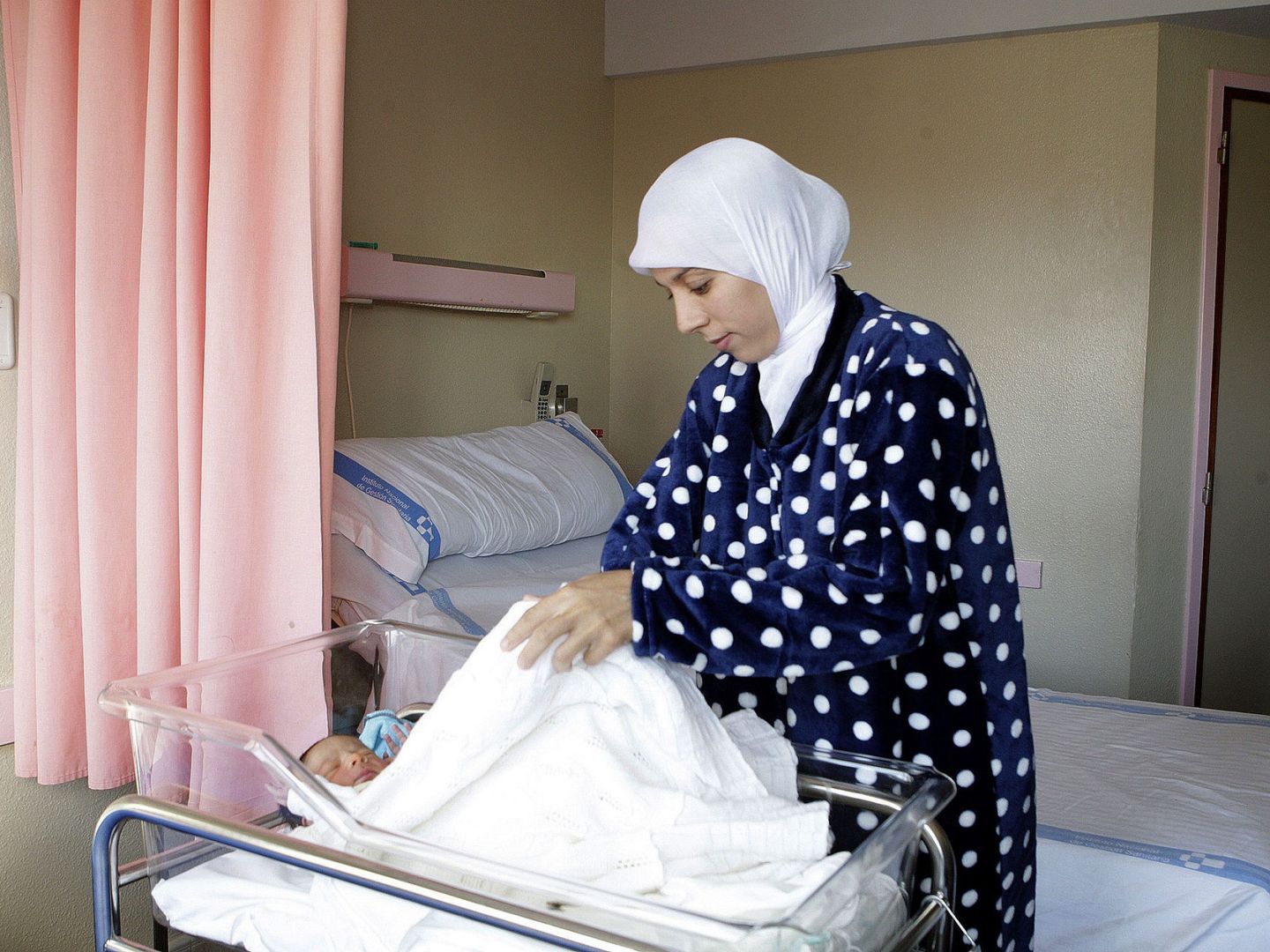 Sonia, venida de la zona de Nador, la ciudad marroquí vecina de Melilla, para dar a luz a su niño, cuida de su bebé en una habitación del Hospital Comarcal de Melilla. (EFE)