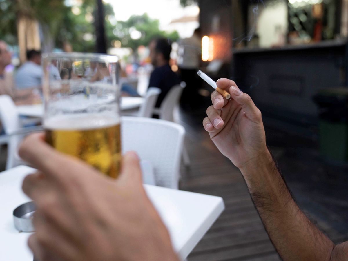 Foto: Una persona sostiene un cigarrillo en la terraza de en un bar en Santa Cruz de Tenerife. (EFE) 