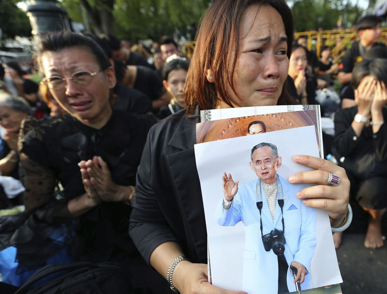 Mujeres con retratos del rey Bhumibol lloran su muerte frente al Gran Palacio de Bangkok, Tailandia.(EFE) 