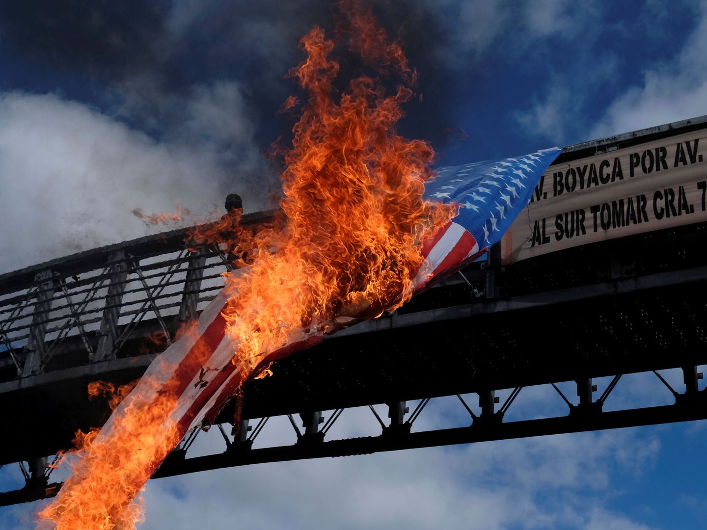 Manifestantes prenden fuego a una bandera de EEUU en Bogotá. (Reuters)