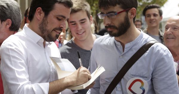 Foto: El candidato de Unidos Podemos Alberto Garzón firma un libro a un simpatizante en Zaragoza. (EFE)