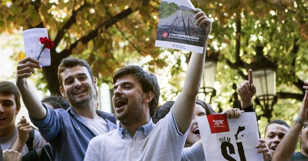 Foto:  Varios jóvenes muestran carteles y papeletas del referéndum durante la concentración ante la consellería de Economía. (EFE)