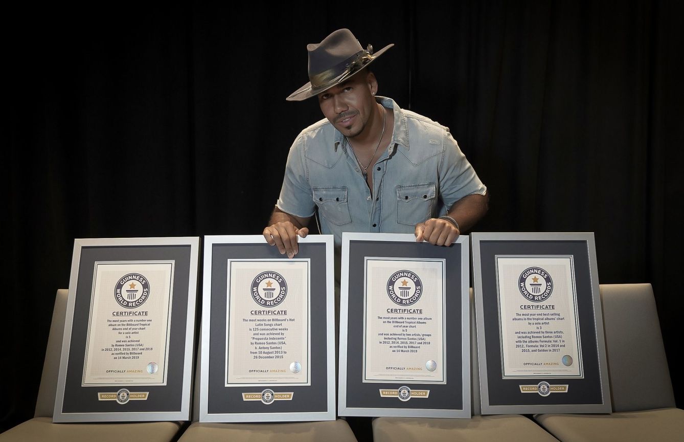 Romeo Santos posando con sus cuatro certificados de récord Guinness. (EFE)