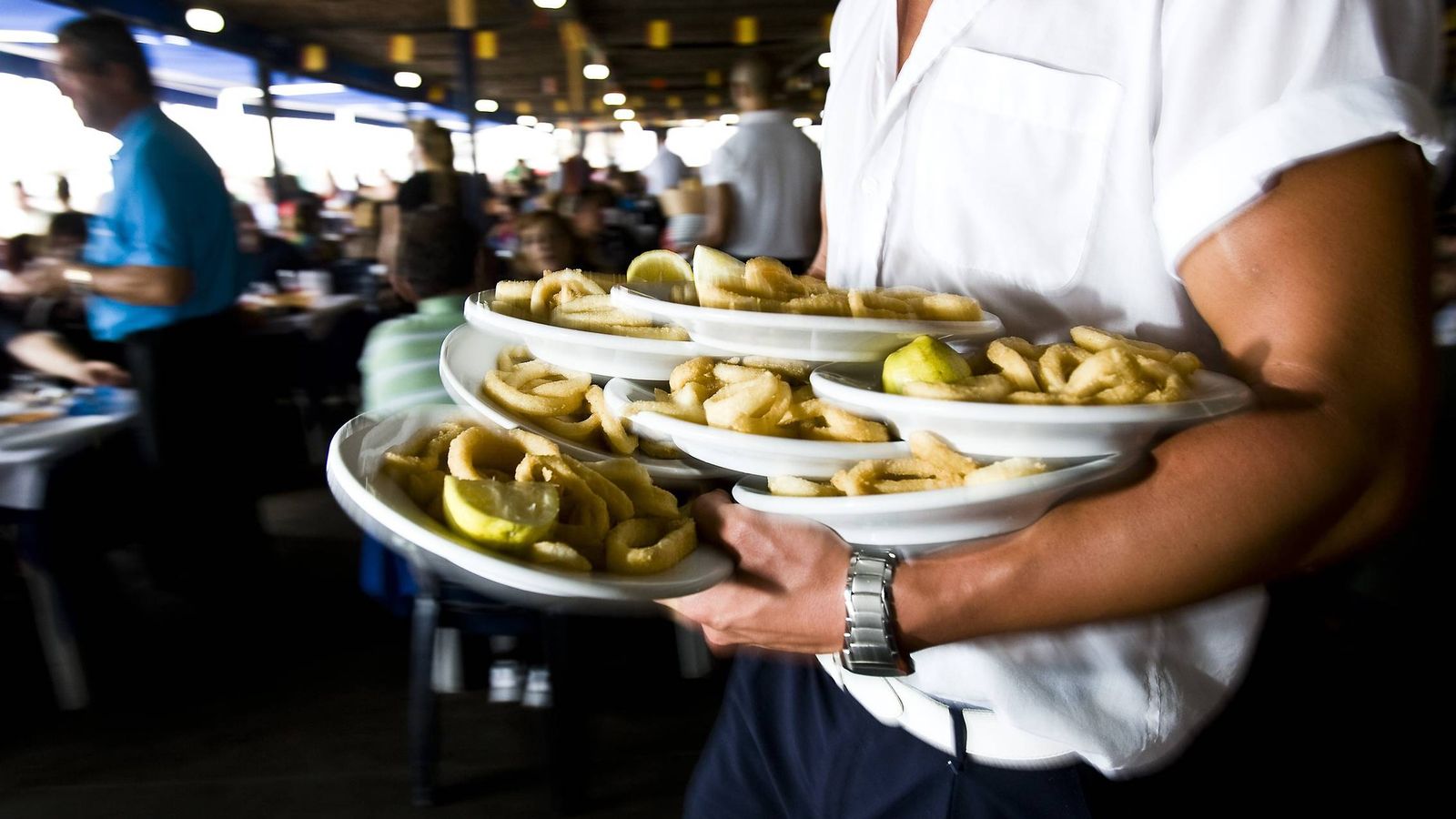 Foto: Un camarero porta varios platos en un chiringuito de Málaga. (EFE)