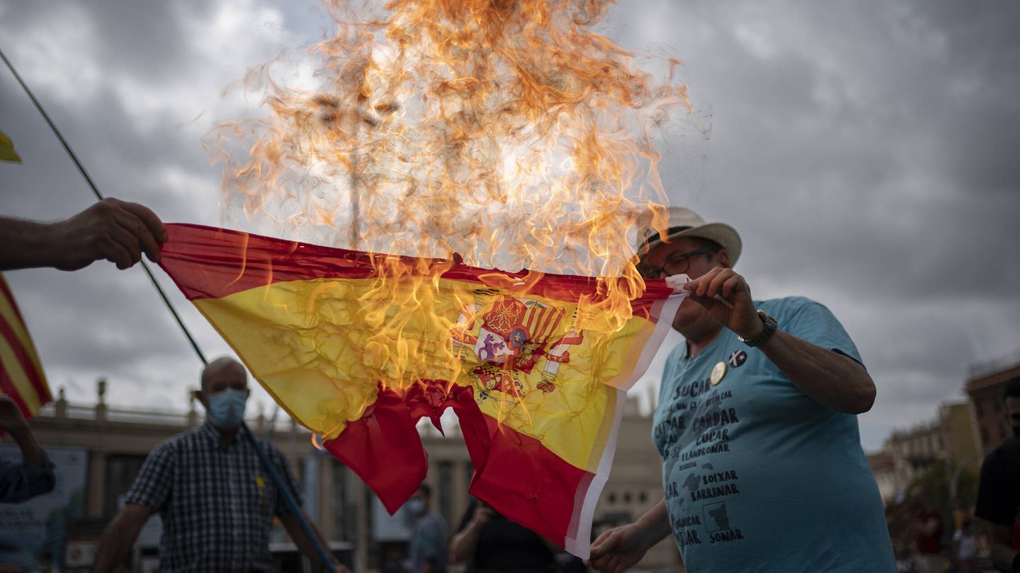Un manifestante independentista quema una bandera de España durante una manifestación contraria al rey Felipe VI. (Joan Mateu Parra)