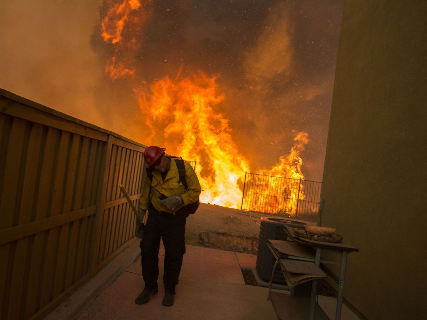 Un bombero trata de apagar un incendio hoy, en Corona, California. (EFE)