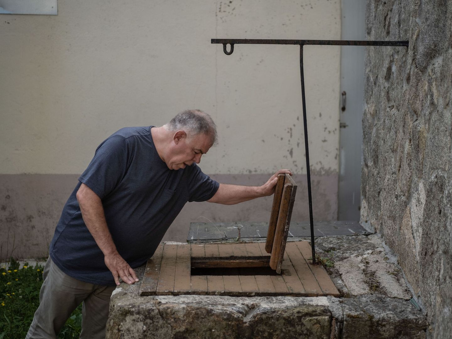 José Salvador, vecino del pueblo de San Mamede (Porqueira), observa un pozo con el que se abastece del agua que también comparte con sus vecinos. (EFE/Brais Lorenzo)