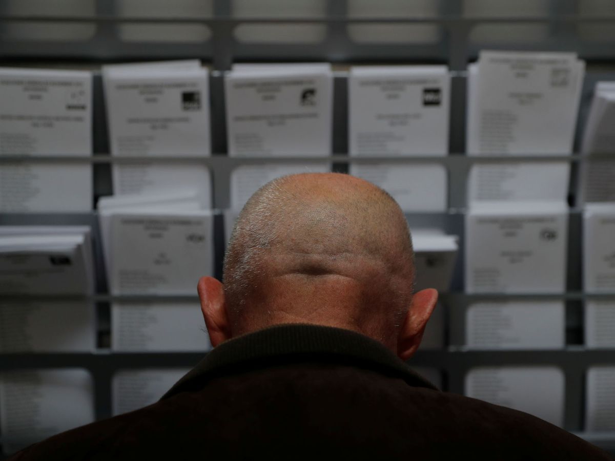 Foto: Un votante, frente a las papeletas de los partidos en las elecciones generales. (Reuters)