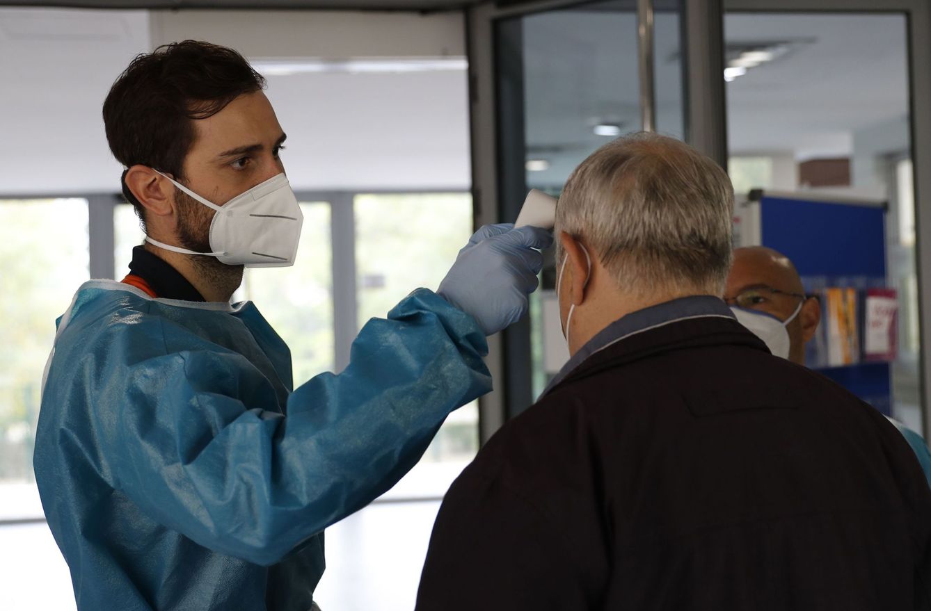 Un sanitario controla la temperatura a un paciente en un centro de salud en Madrid. (EFE)