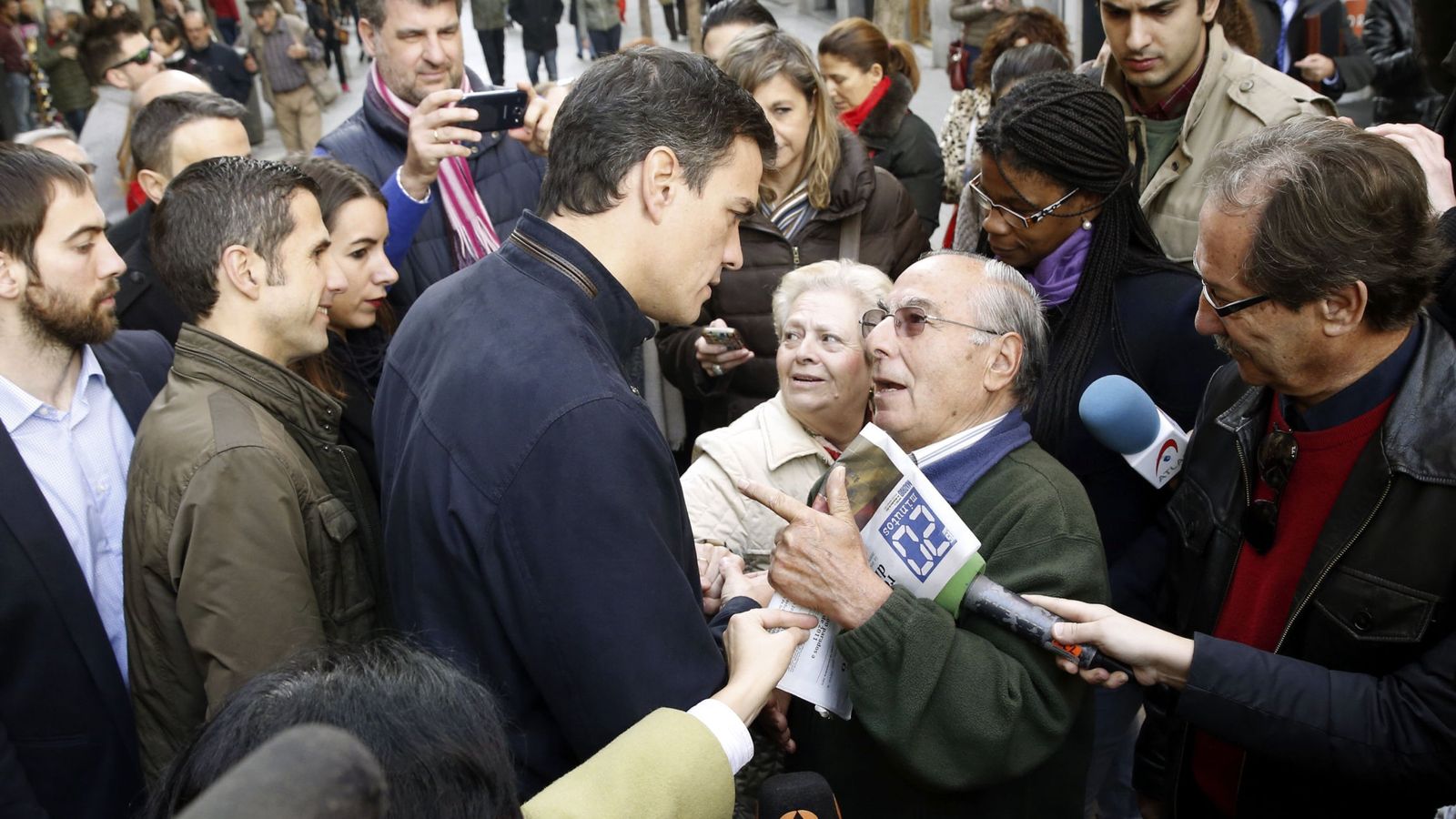 Foto: Pedro Sánchez conversa con un ciudadano durante su paseo por la céntrica calle de Fuencarral de Madrid, este 17 de diciembre. (EFE)