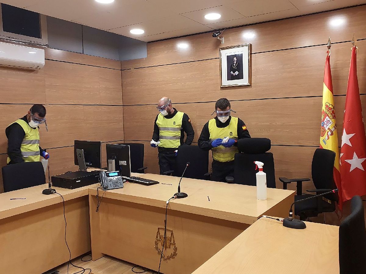 Foto: Fotografía facilitada por la UME, cuyos miembros proceden a la desinfección del interior de los juzgados de Plaza Castilla en Madrid. (EFE)