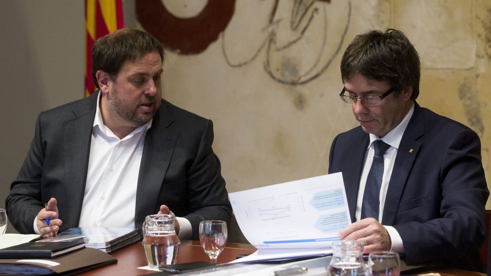 Foto: Oriol Junqueras y Carles Puigdemont miran el dossier con los presupuestos del 2017. (EFE) 
