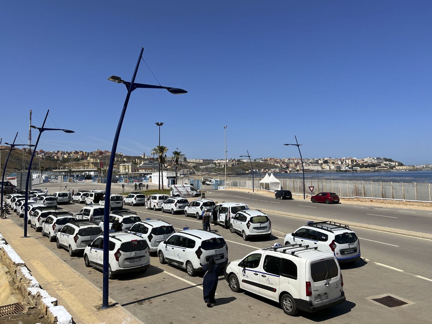 Taxis esperando a clientes que salen de Ceuta por el paso fronterizo del Tarajal. (EFE/Mohamed Siali)