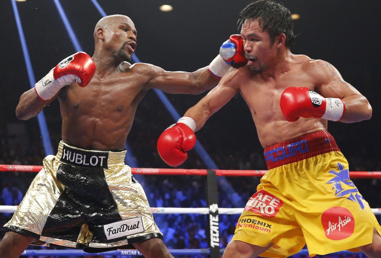 Floyd Mayweather, Jr. (L) of the U.S. lands a left to the face of Manny Pacquiao of the Philippines in the 11th round during their welterweight WBO, WBC and WBA title fight in Las Vegas, Nevada, in this May 2, 2015 file photo.  Boxers Mayweather and Pacquiao topped Forbes 2015 list of the world's highest-paid celebrities June 29, 2015, thanks to their record-breaking lucrative Las Vegas fight that assured them earnings that surpassed those of musicians and actors.  REUTERS/Steve Marcus/Files