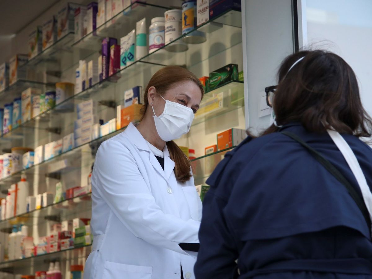 Foto: Una clienta conversa con una empleada a las puertas de una farmacia del centro de Madrid. (EFE)